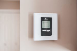 Simple modern thermostat on white wall